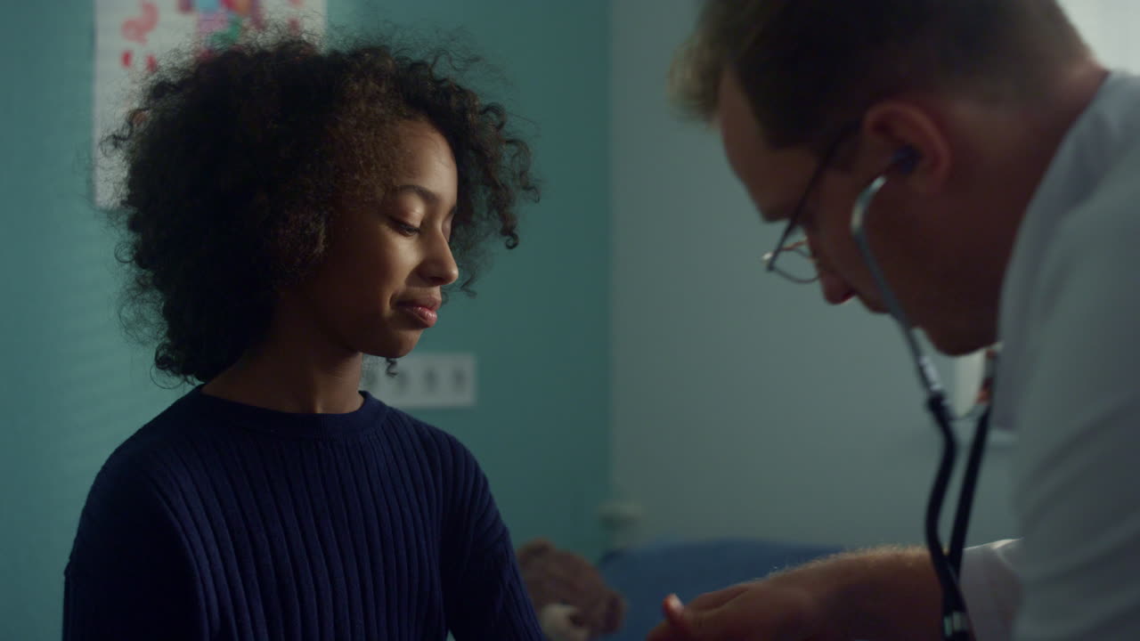 Girl patient visit pediatrician on health examination. Doctor using stethoscope.