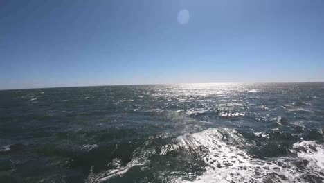 tiro de ondas ondulando através do oceano em um dia claro e ensolarado