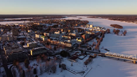 tornio city in frozen river torne delta in wintertime, aerial pullback