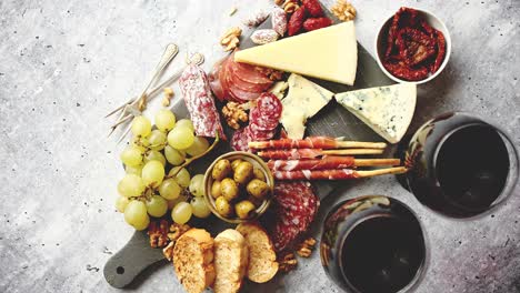 cold snacks board with meats  grapes  wine  various kinds of cheese