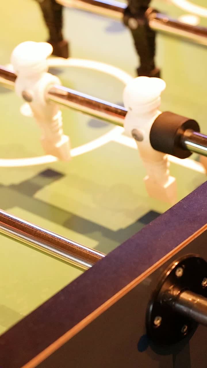 manos hábilmente maniobrando las barras de futbolín en acción