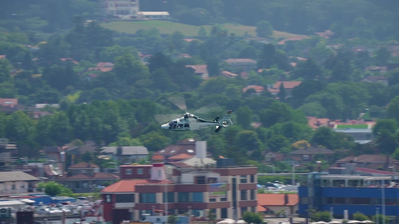 Helikopter sipil menengah terbang di atas pemandangan gunung berkabut
