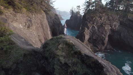 Mujer-En-La-Costa-De-Oregon---Revelación-De-Inclinación-Aérea-Cinematográfica,-Concepto-De-Pasión-Por-Los-Viajes