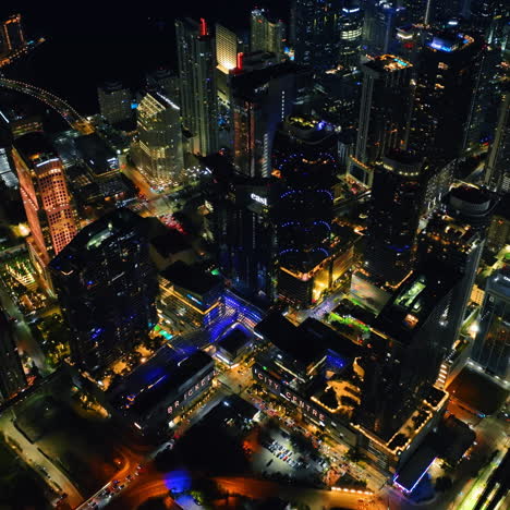 flying closer to the tops of skyscrapers in the downtown of miami, florida. stunning view of usa city at night.