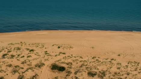 aerial beach view with peaceful calm sea surface washing on coastline.