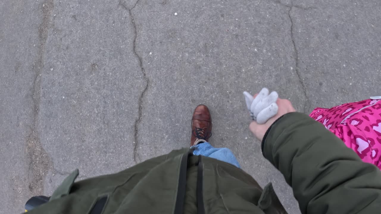 Dad gives hand to daughter and walking, POV