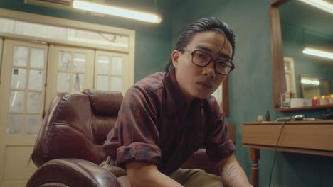 handsome asian barber posing on camera with confidence