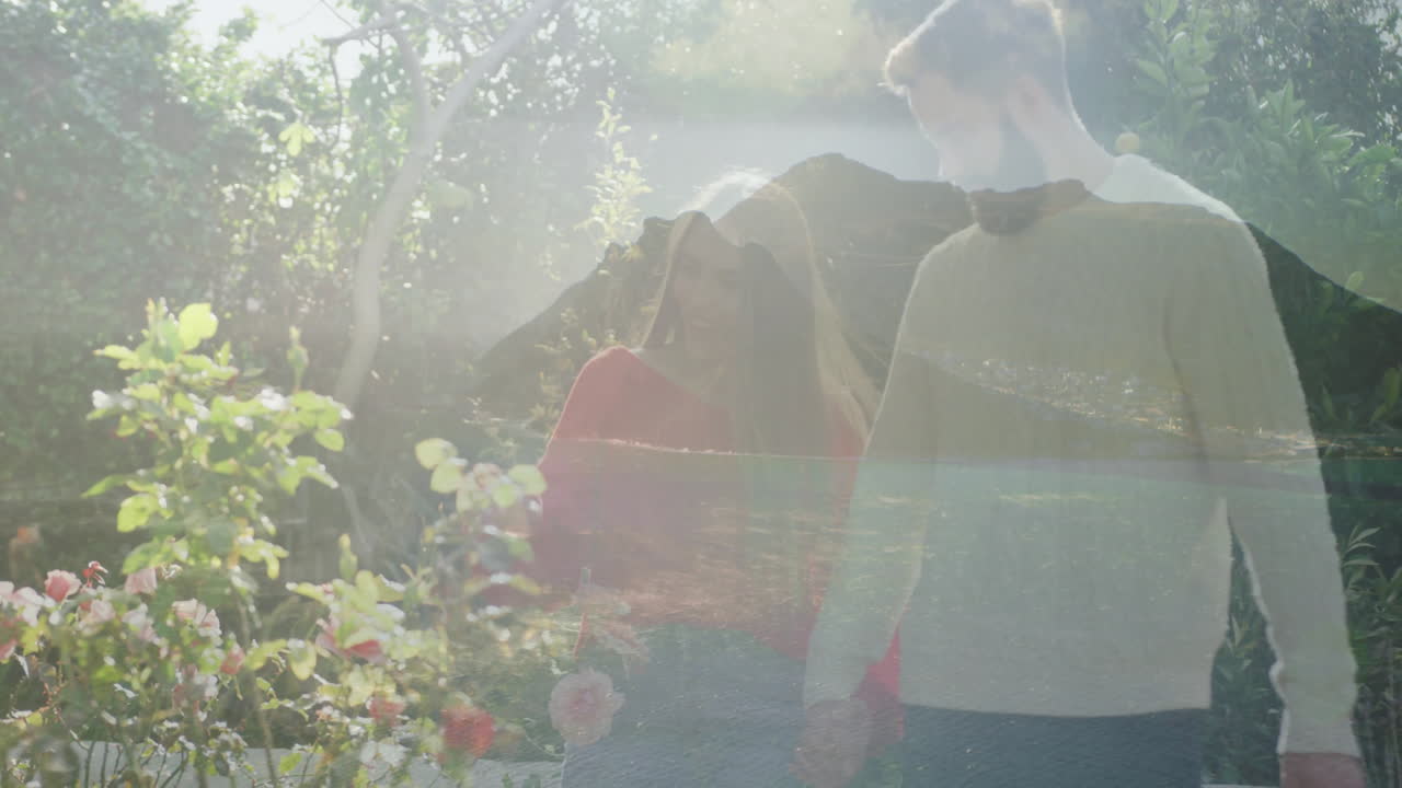 In garden, couple walking as sunlight filtering through trees, enjoying nature