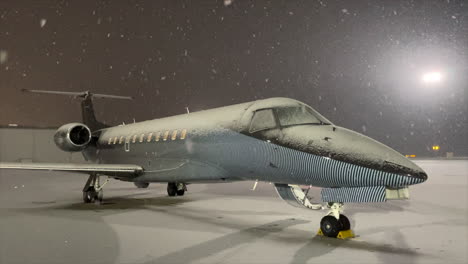 copos de nieve cayendo en un avión privado de lujo en la plataforma del aeropuerto de invierno