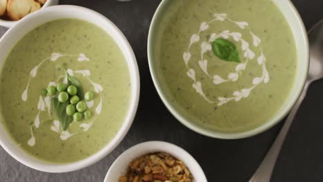 Video-Von-Grüner-Erbsensuppe-Und-Zutaten,-Die-Auf-Einer-Grauen-Oberfläche-Liegen