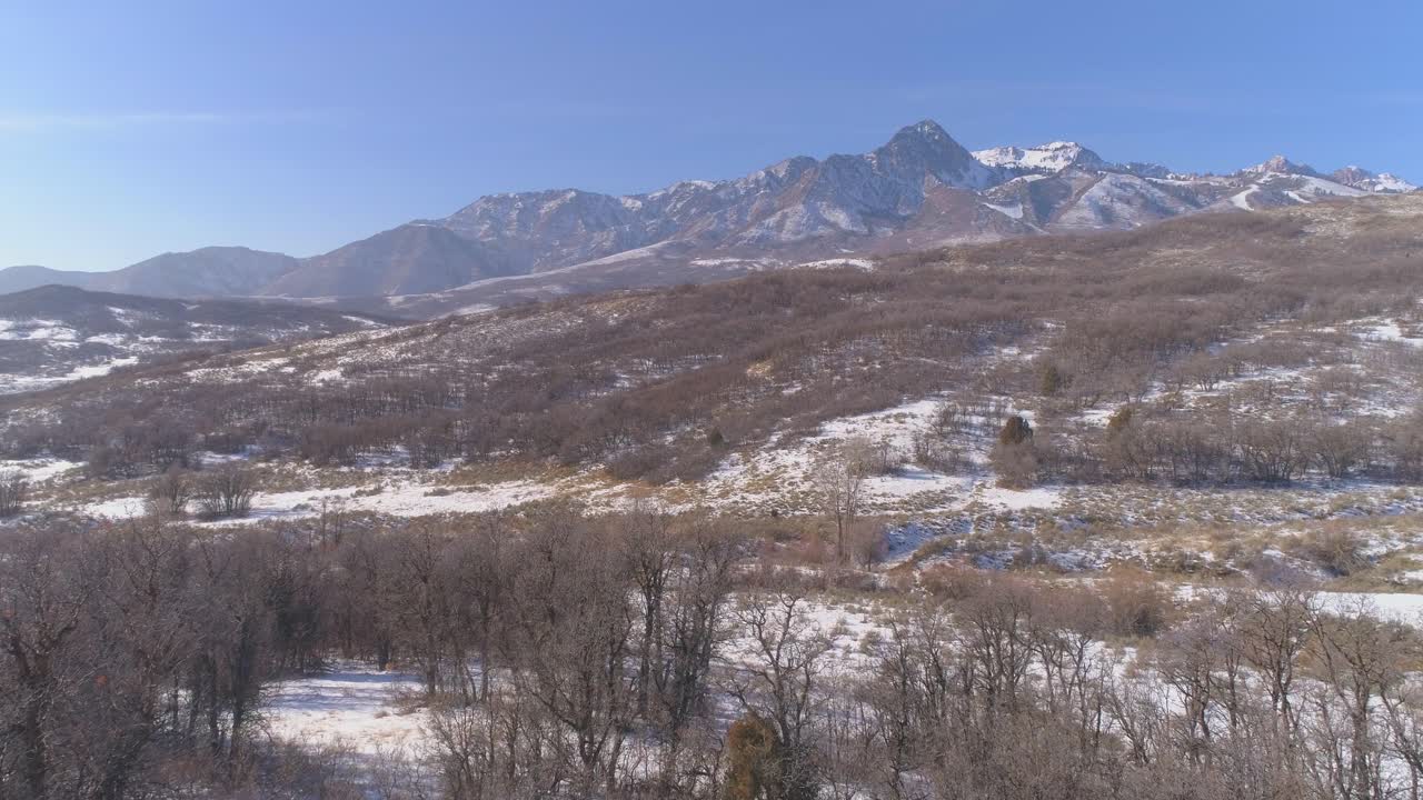 Ripresa con drone di un minuto in volo sopra la base di una montagna innevata