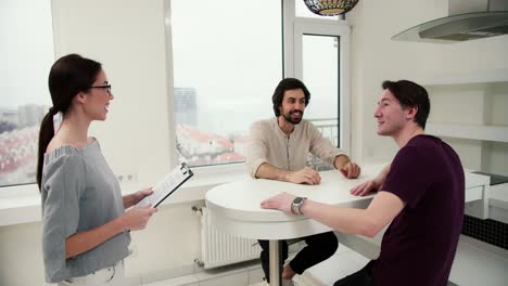 attractive male couple viewing a property together with agent, enjoying new interior