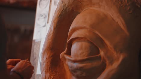 artist passionately molds a captivating big eye statue from clay in their workshop