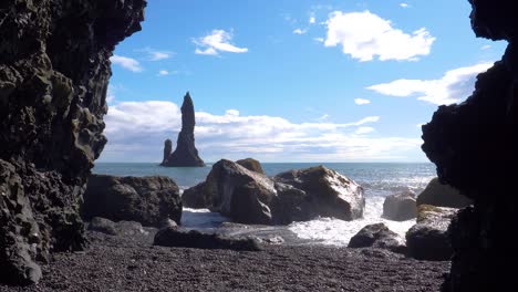 view of reynisfjara black beach iceland on sunny day as waves crash on rocks, static