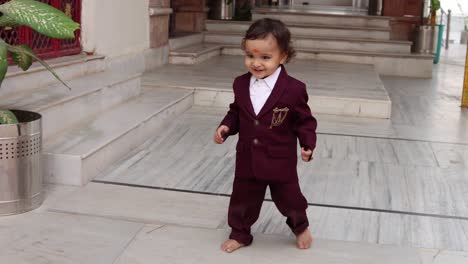 cute indian toddler walking in suit at outdoor from different angle