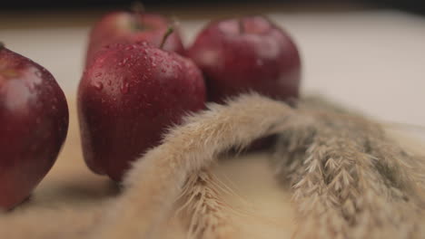 manzanas frescas en una mesa con luz cálida y fondo negro en un ambiente oscuro interior con accesorios simples dispuestos uno al lado del otro