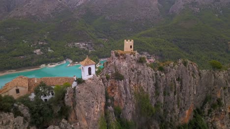 drone flight crossing close to a battlement of an old medieval castle on the top of a rock of a spanish village