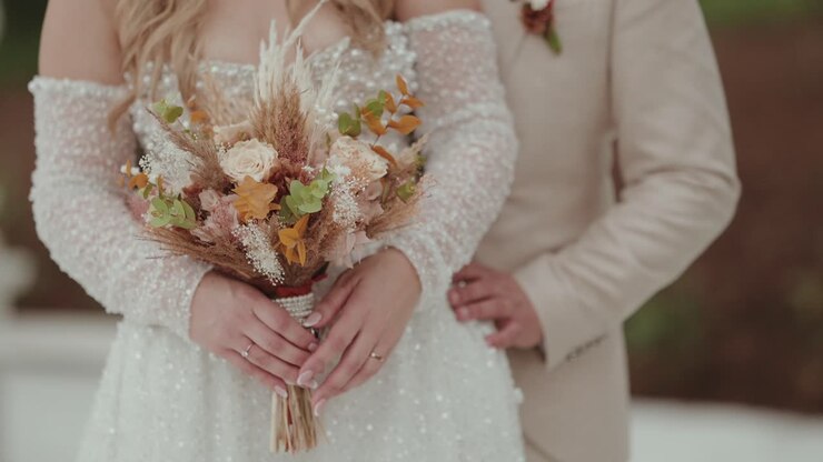 Close up of bride hands holding natural dried wedding bouquet