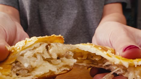 양파 가득 찬 맛있는 페이스트리를 들고 있는 여자