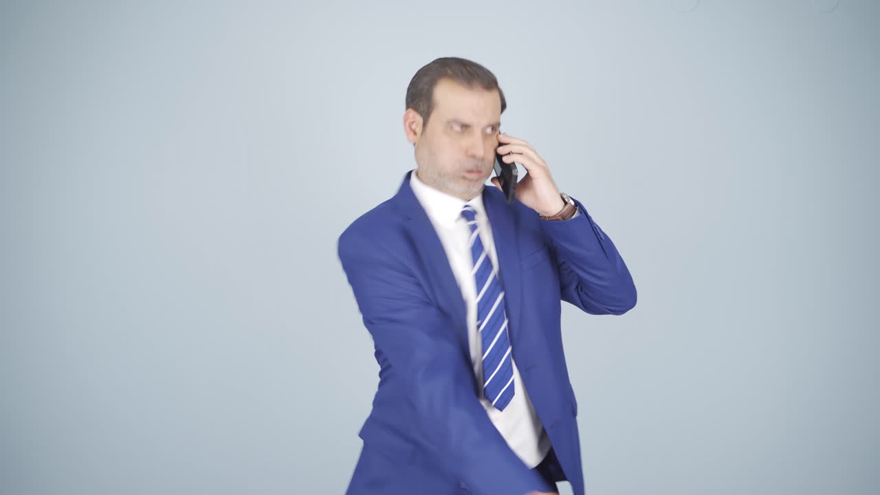 화난 사업가가 전화하고 있어요.