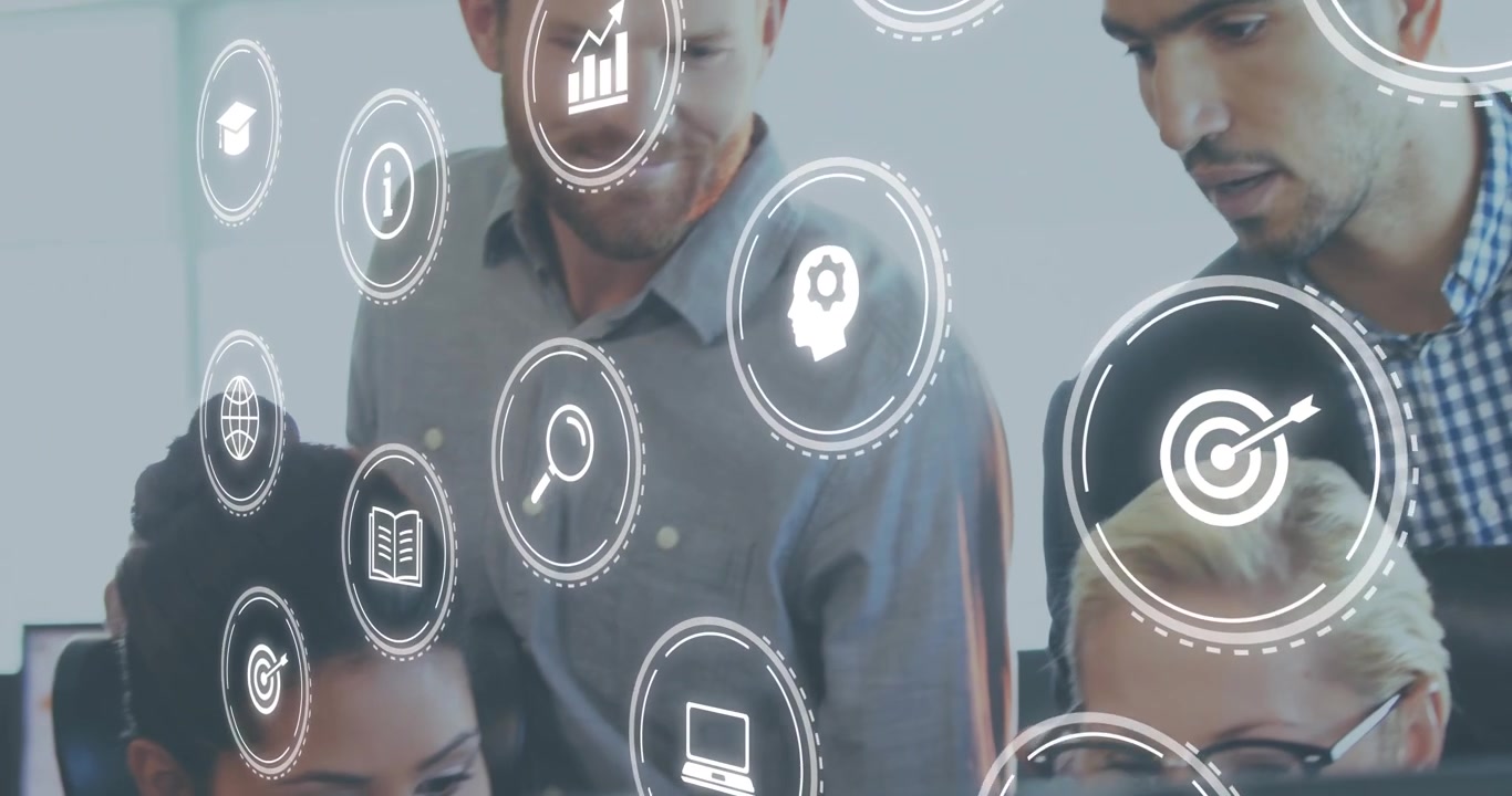 Seated colleague clicking screen launching floating data icons while business team analyzing data