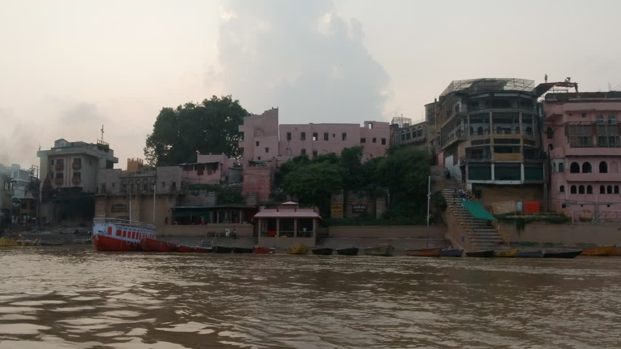 cinematográfica antigua ciudad santa varanasi india río ganges la gente se reunió en un crucero en barco por el canal del estado norte la gente en la provincia de ghat pradesh el paisaje gris nublado a la derecha seguir el movimiento lento a la derecha