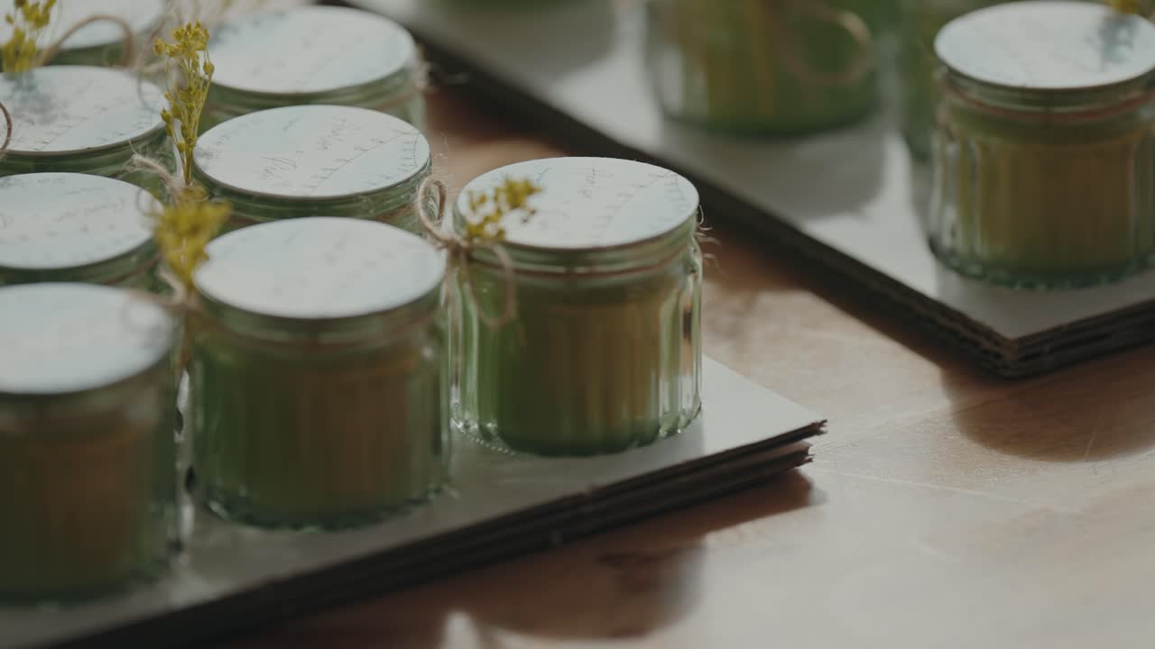Shot of neatly arranged glass jars with tied flowers on a tray
