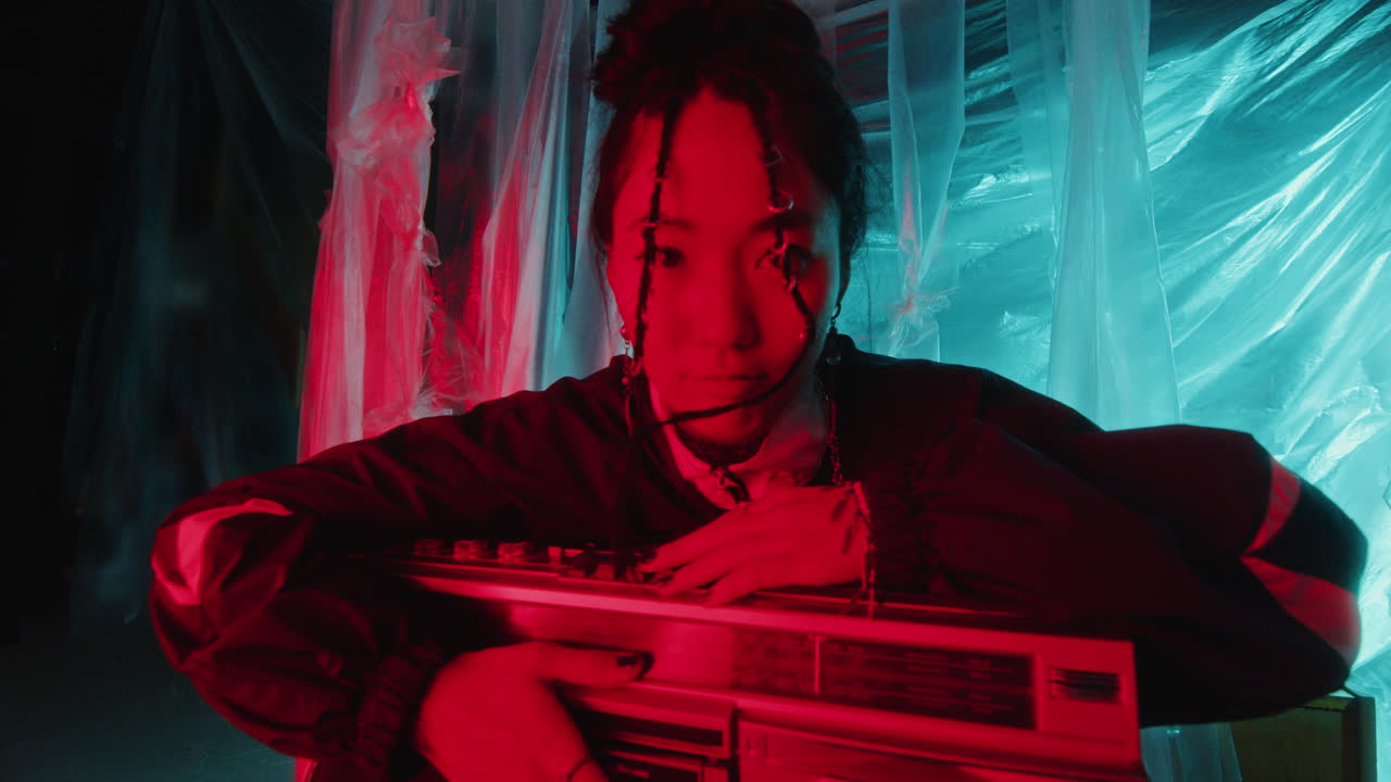 Portrait of Pretty Asian Woman with Retro Boombox in Multicolored Neon Light