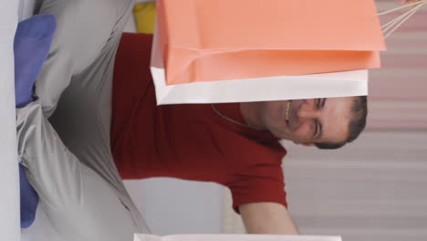 Vertical-video-of-Man-looking-at-camera-with-shopping-bags.