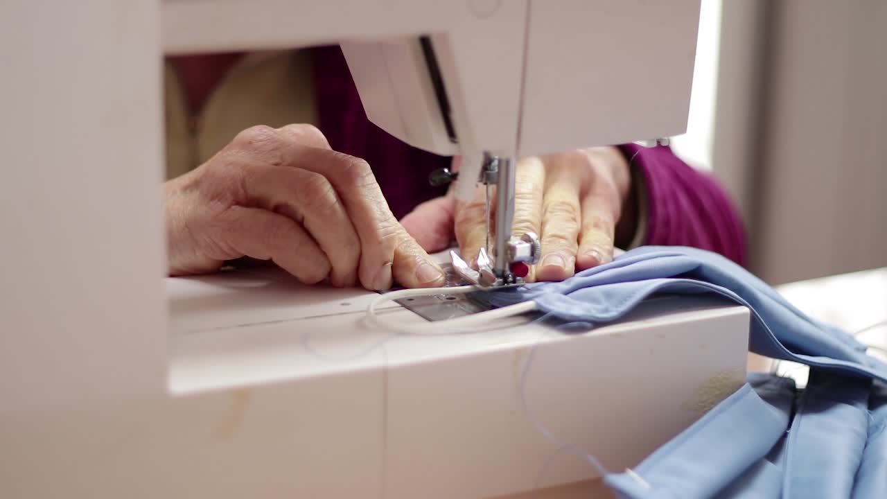 Seamstress sews corona virus protective mask with sewing machine
