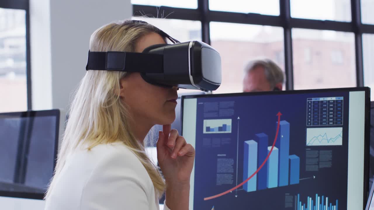 Caucasian businesswoman using vr headset at desk in office