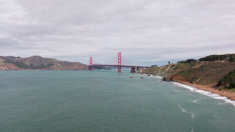 low drone shot rising up and showing the golden gate bridge in san francisco