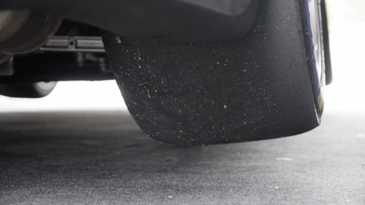 프로 독일 gt3 경주용 자동차가 에어 리프트 잭에서 슬로우 모션으로 지상에 내려오고 있습니다.