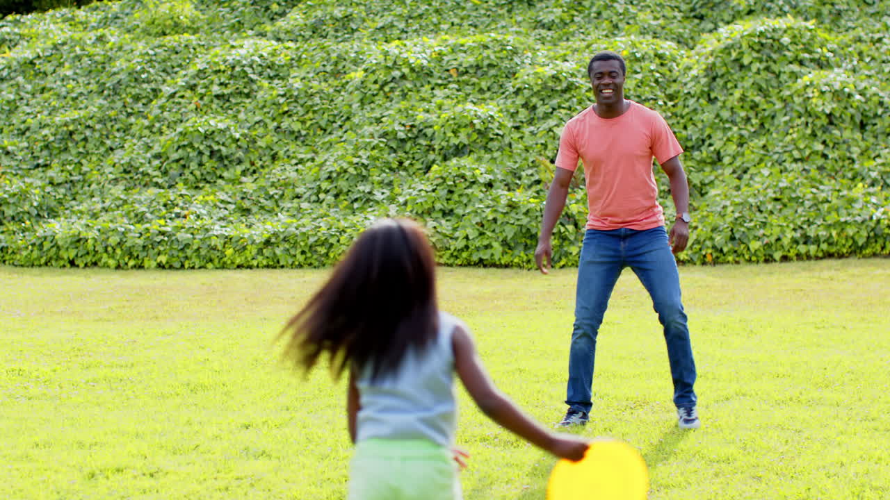 African American, Father and daughter playing catch in sunny park, enjoying outdoor fun together, co