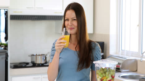 Mujer-Sonriente-Bebiendo-Un-Vaso-De-Jugo-De-Naranja