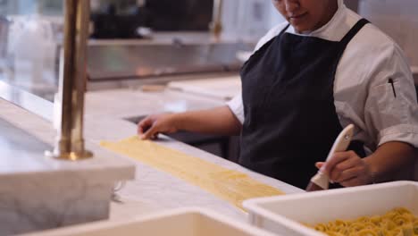chef femenina cepillando lasaña hecha a mano, mediana
