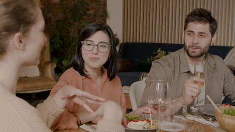 young female tells a story to her group of friends at a dinner party