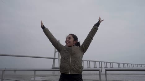 mujer hindú feliz con los brazos extendidos en la orilla del mar