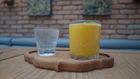 orange juice and water on a wooden tray