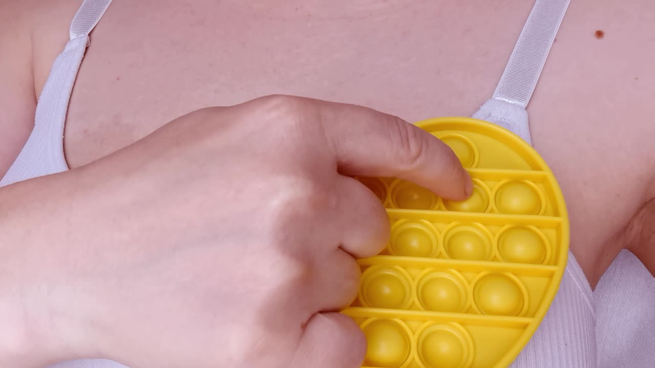 새로운 아기 장난감. 손가락 놀이. 재미있는 색. 성인 손 압축 둥근 실리콘. 형태 변경. 노란색 심장 모양