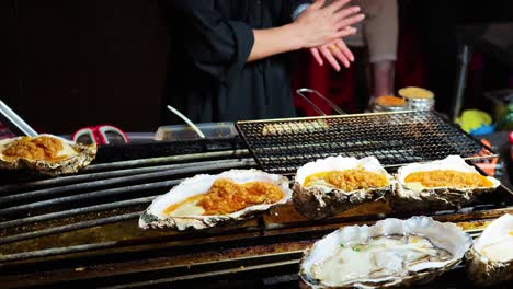 oysters being grilled at a street food stall