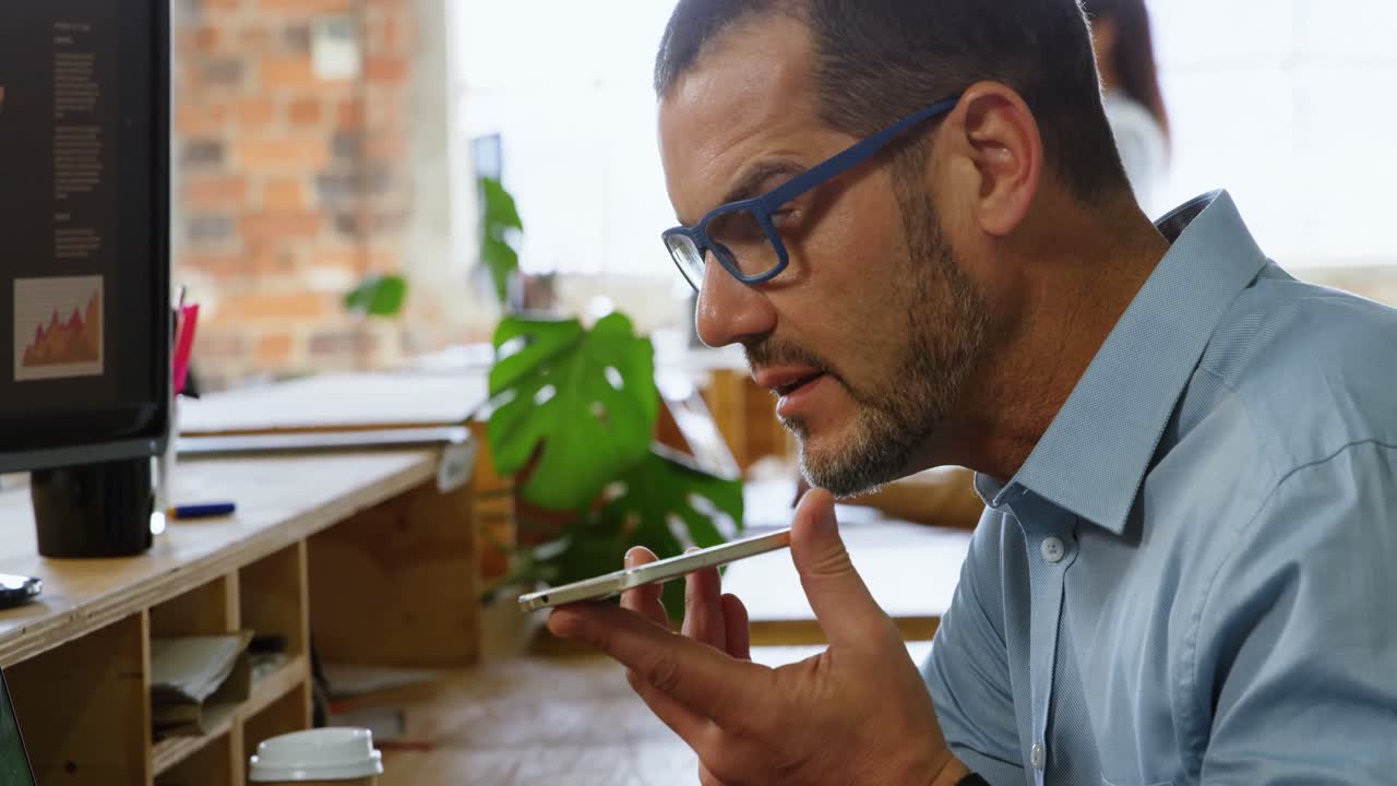 ejecutivo hablando por teléfono móvil en el escritorio en la oficina 4k