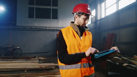 Engineer-works-in-a-warehouse-and-uses-a-tablet-2