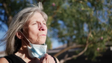una anciana paciente con una máscara de hospital respirando aire fresco en sus pulmones después de un tratamiento para su enfermedad