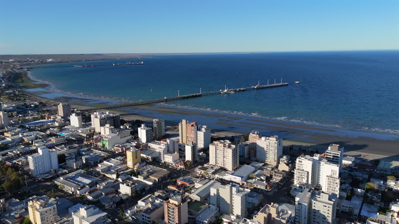 Aerial establishing of Puerto Madryn, coastal Patagonian city in Chubut Province, Argentina, waterfront buildings over Atlantic blue ocean