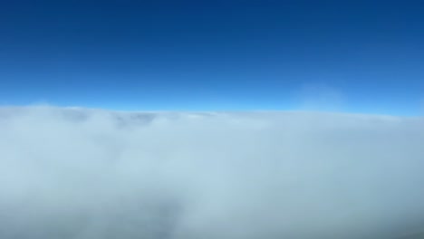 lapso de tiempo aéreo disparado desde un avión volando a través de algunas nubes en un día soleado con un cielo azul profundo