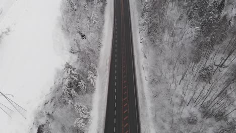 Fliegen-über-Asphaltstraße-Im-Winterwald---Drohnenaufnahme-Aus-Der-Luft