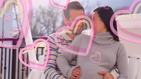 animación de iconos de corazón sobre un hombre caucásico feliz abrazando a su esposa embarazada