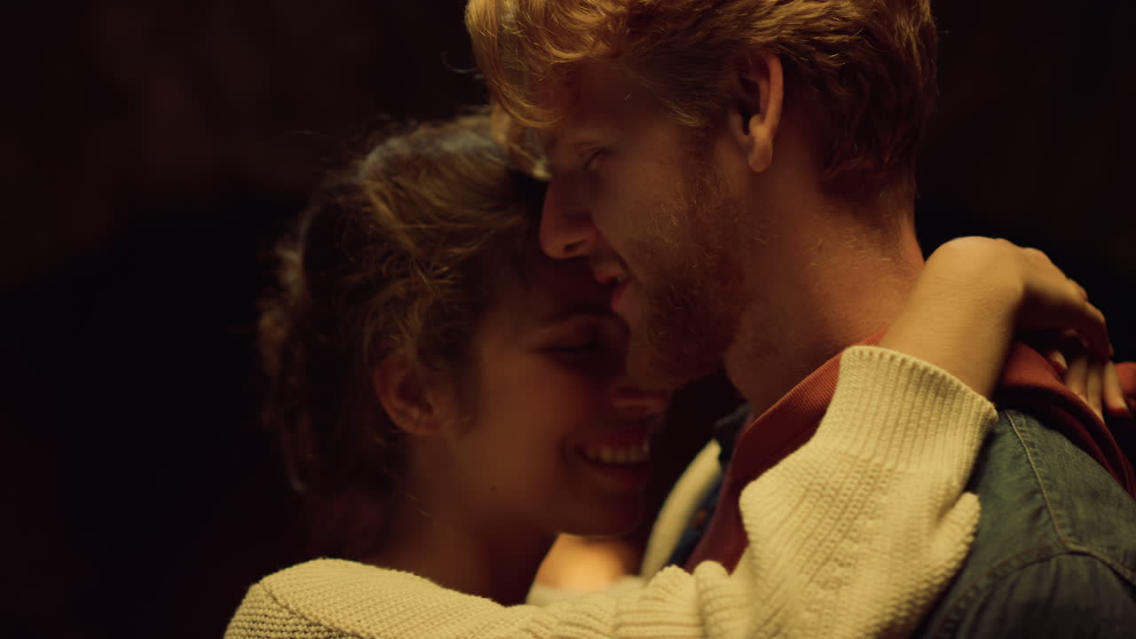 Joyful couple embrace together at night date. Lovely husband wife enjoy fire.