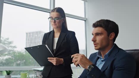 Executive-talking-office-assistant.-Thoughtful-woman-taking-notes-plan-schedule